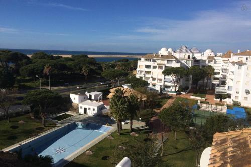 uma vista aérea de um resort com uma piscina em Coqueto apartamento a un tiro de piedra de la playa del Portil em El Portil