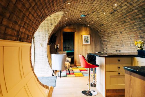 an archway in a kitchen with a red stool at Rabbit Warren in Llansantffraid-ym-Mechain