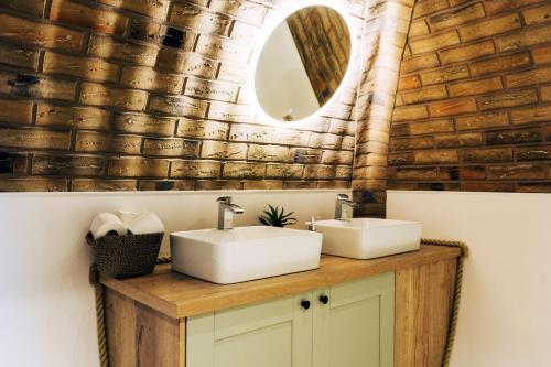 a bathroom with two sinks and a mirror at Rabbit Warren in Llansantffraid-ym-Mechain