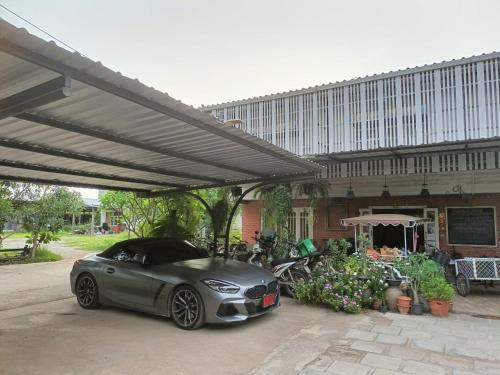 スコータイにあるAenguy Hostelの建物前の天蓋下に駐車した銀車