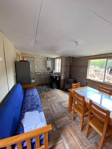 ein Wohnzimmer mit einem blauen Sofa und einem Tisch in der Unterkunft Cabaña a 8 km de Cerro Castillo. in Villa Cerro Castillo