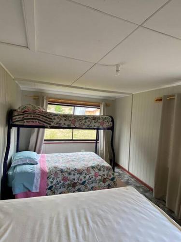 1 dormitorio con 2 camas y ventana en Cabaña a 8 km de Cerro Castillo., en Villa Cerro Castillo