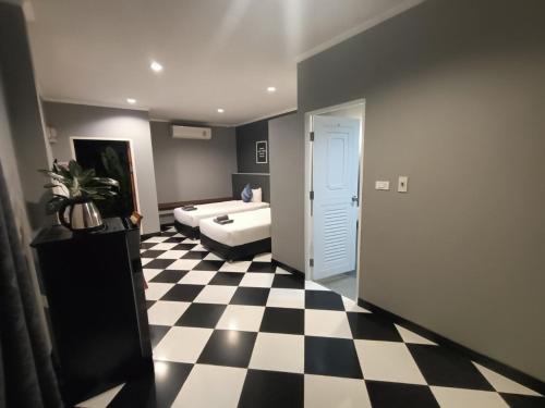 a room with a checkered floor and a bedroom with a bed at Aen Guy Boutique Hotel in Sukhothai