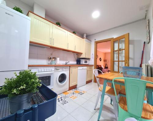 cocina con mesa y lavadora en Apartamentos Dos Torres pasaje de los Giles, en Zaragoza