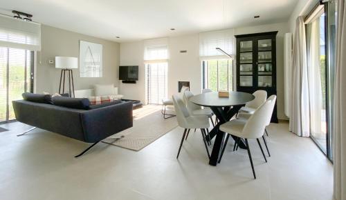 a living room with a couch and a table and chairs at Waterrijk Oesterdam Resort Villas in Tholen