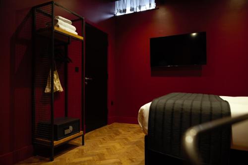 una camera rossa con letto e TV di Duke Street Boutique Hotel a Liverpool