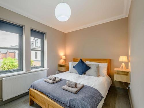 1 dormitorio con 1 cama con 2 toallas en Westertonhill Lodge 8 Newbuild with Hot Tub Option, en Balloch