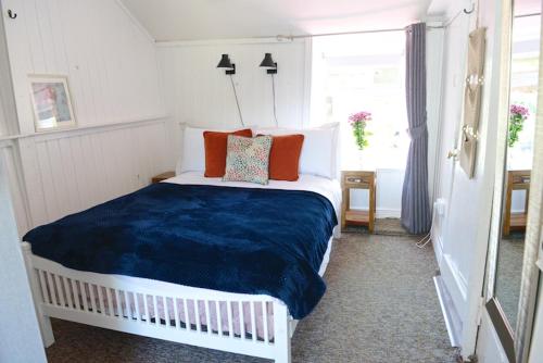 a bedroom with a large bed with a blue blanket at Corderry Farmhouse, idyllic cottage amid 250 acres in Stagdale Bridge