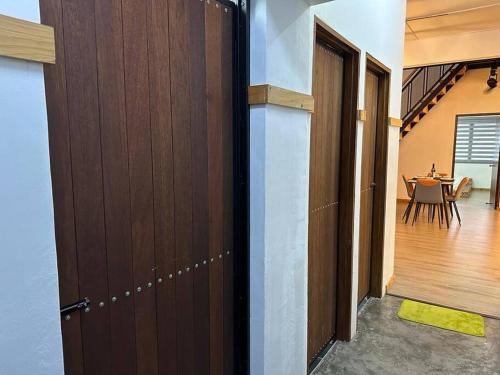 a room with a door and a dining room with a table at Ipoh Family Homestay Masjid Muhammadiah Evicharger SY16 in Ipoh