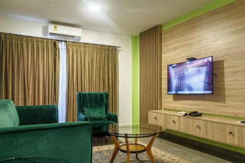 a room with two chairs and a tv on a wall at OASIS PARK RESIDENCE in East Legon