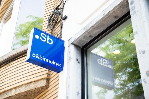 un panneau bleu sur le côté d'un bâtiment dans l'établissement Bed & Binnekyk, à Malines