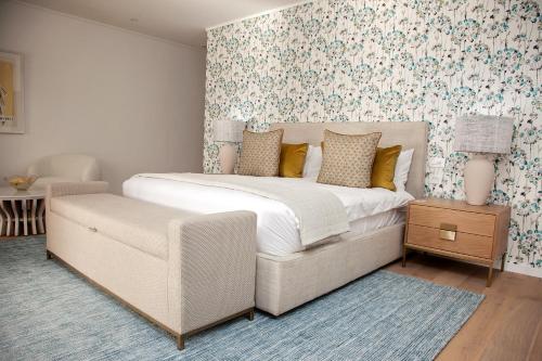 a bedroom with a large bed and a chair at La Petite Ferme in Franschhoek