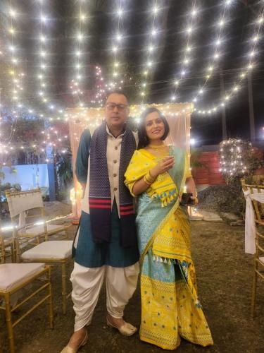 a man and a woman standing in front of a tent at Homestay by the Tea Garden Dibrugarh in Dibrugarh