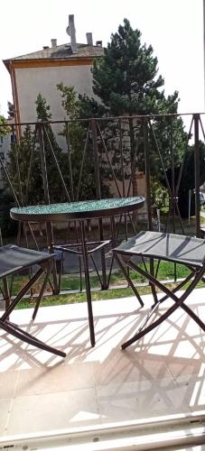 a picnic table and benches sitting on a patio at Karancs Apartman Salgótarján in Salgótarján