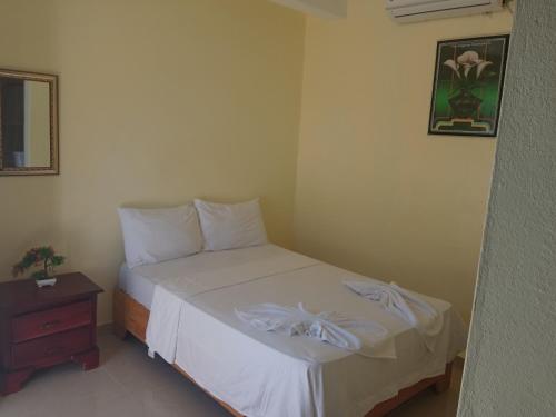 a small bedroom with a bed and a table at Salemar Hostal - Cerca de la playa in Sosúa