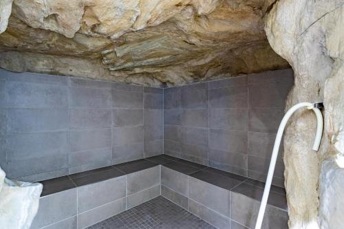 a shower in a cave with a stone wall at Seehotel Fährhaus in Bad Zwischenahn