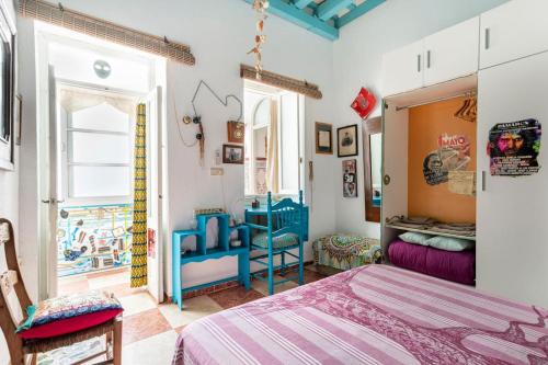 1 dormitorio con cama, mesa y ventana en Habitaciones La Pepa, en Cádiz