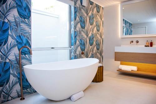 a bathroom with a large white tub and a sink at La Petite Ferme in Franschhoek