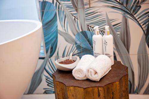a bathroom with towels on a wooden stump with a sink at La Petite Ferme in Franschhoek