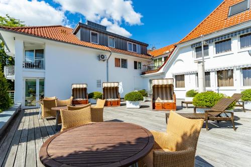 a patio with a wooden table and chairs at Seehotel Fährhaus in Bad Zwischenahn