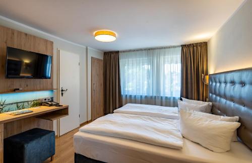 a hotel room with a bed and a desk at Seehotel Fährhaus in Bad Zwischenahn