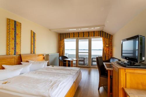 a hotel room with a bed and a television at Seehotel Fährhaus in Bad Zwischenahn