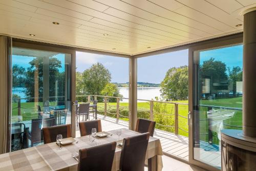a dining room with a view of the water at Golden Lakes Village Ardennes in Boussu-lez-Walcourt