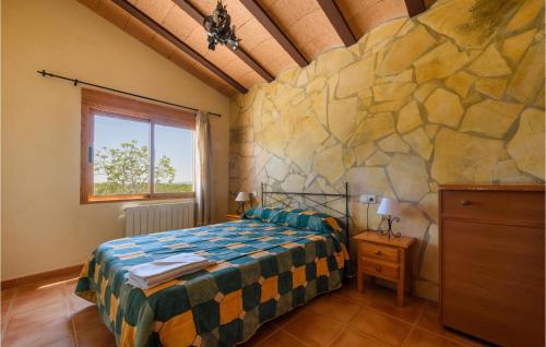 ein Schlafzimmer mit einem Bett und einer Steinmauer in der Unterkunft Gorgeous Home In Caravaca De La Cruz With Outdoor Swimming Pool in Inazares
