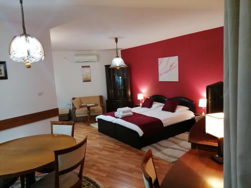 a bedroom with a bed and a dining room with a table at Petkov Family Hotel in Blagoevgrad