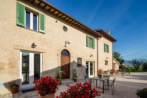 a building with a table and chairs in front of it at L'ORTIGIANO in Foligno