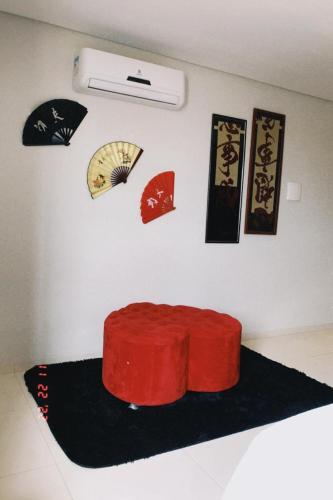 a room with a red cushion on a wall with posters at Pak Suítes Hotel in Luis Eduardo Magalhaes