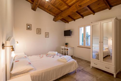 a bedroom with a large white bed and a window at L'ORTIGIANO in Foligno