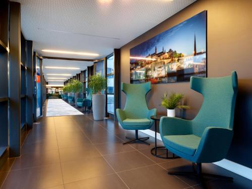 a corridor of a hospital with chairs and plants at Park Inn by Radisson Luxembourg City in Luxembourg