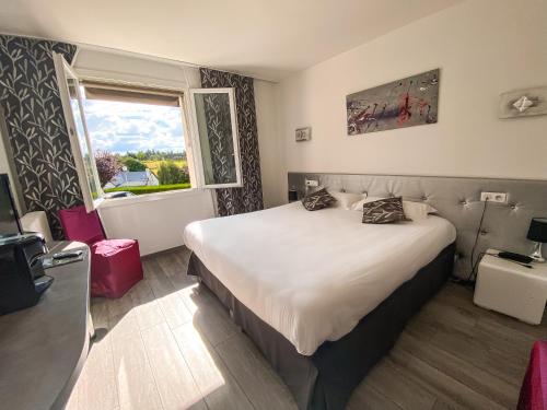 a hotel room with a large bed and a window at Logis Hôtel et Spa Chez Camillou in Aumont-Aubrac