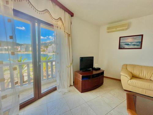 un soggiorno con TV e una grande finestra di Sea view Apartments Rafailovici DOO PLAVA VILA a Budua