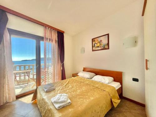 una camera con un letto e una grande finestra di Sea view Apartments Rafailovici DOO PLAVA VILA a Budua