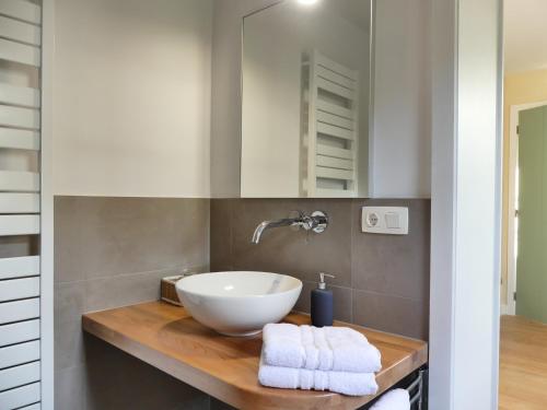 een badkamer met een witte wastafel op een houten aanrecht bij Het Zilte in Zuidzande