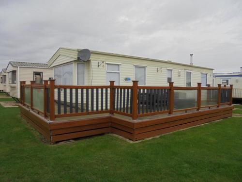 a deck with a wooden railing on a house at 6 Berth heated on The Chase Brisbane in Ingoldmells