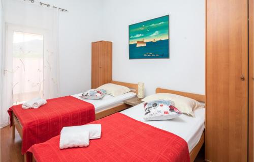 two beds in a small room with red sheets at Lovely Home In Blato Na Cetini With Kitchen in Blato na Cetini