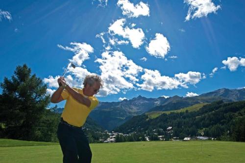 a man is flying a kite in a field at Hotel La Meridiana in Madesimo
