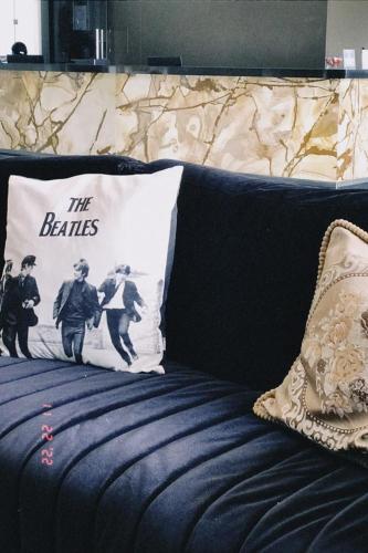 a bed with a pillow with the beatles on it at Pak Suítes Hotel in Luis Eduardo Magalhaes