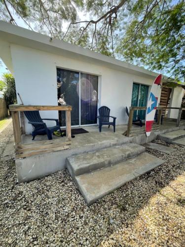 a house with a table and chairs and a surfboard at Las Olas Beach apartments in Arecibo