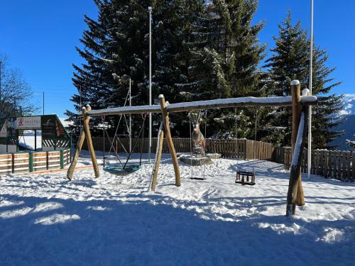 a playground in the snow with a swing at Cosy studio for 5 near ski lift, HAMEAU D2 in Les Collons