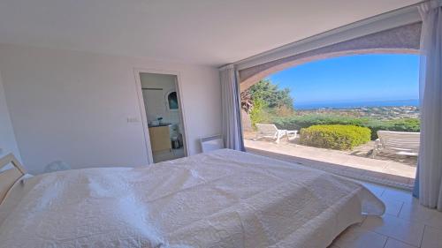 une chambre avec un lit et une grande fenêtre dans l'établissement Villa Lisuzem, à Sainte-Maxime
