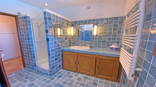 une salle de bain carrelée bleue avec un lavabo et une douche dans l'établissement Villa Lisuzem, à Sainte-Maxime