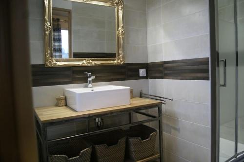 a bathroom with a white sink and a mirror at VILLA BELLE D'OPALE in Wierre-Effroy