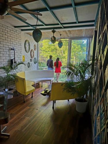 two people standing in a living room with a white piano at Homestay by the Tea Garden Dibrugarh in Dibrugarh