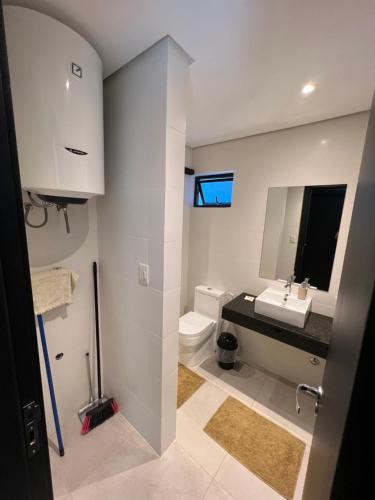 y baño con lavabo, aseo y espejo. en Departamento de 1 habitación - Excelente ubicación- Villa Morra Asuncion #303, en Asunción