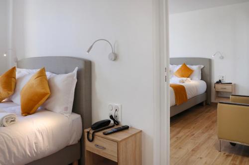 Un dormitorio con 2 camas y una mesa con teléfono. en Les Rebelles, en París