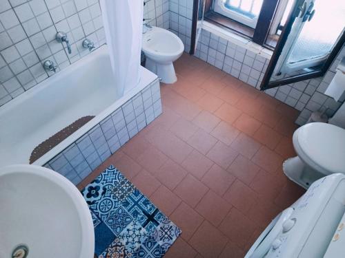 a bathroom with a toilet and a tub and a sink at 4th Floor Bardonecchia in Bardonecchia